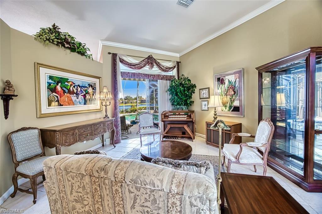 Living area with light tile patterned flooring and crown molding