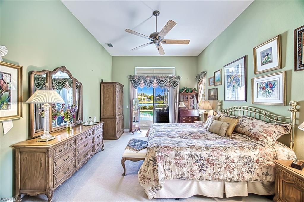 Bedroom featuring access to exterior, light carpet, ceiling fan, and vaulted ceiling