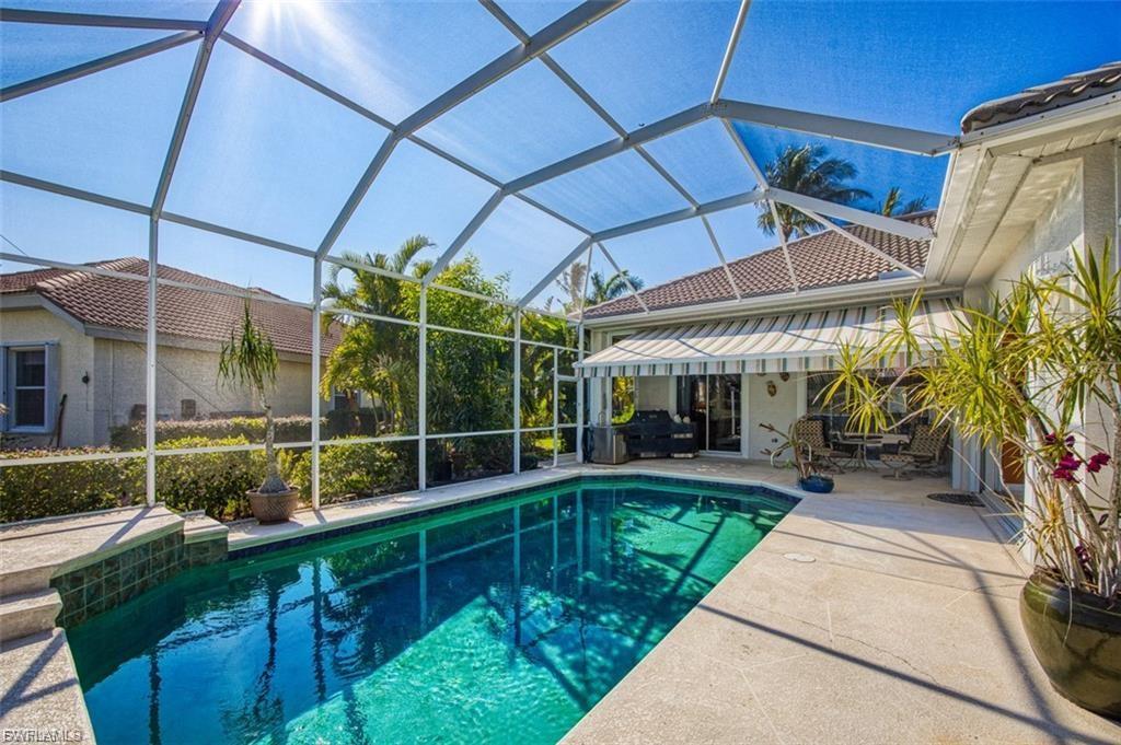 Swimming pool with glass enclosure, a patio area, and a sunroom