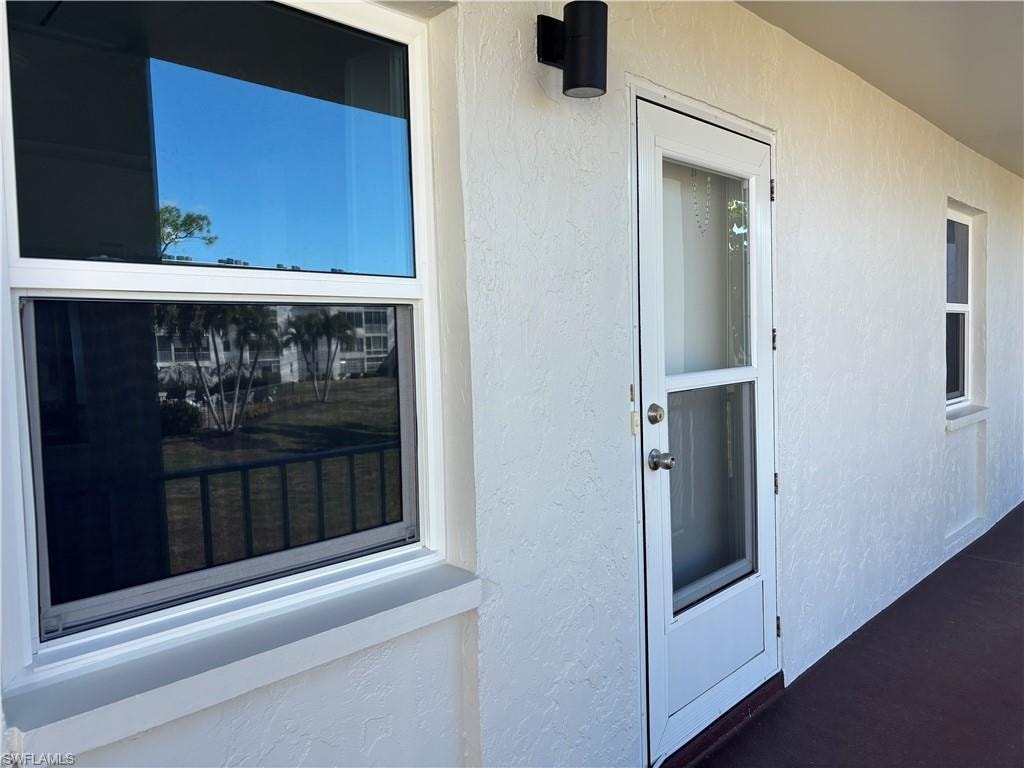 Entrance to property featuring stucco siding