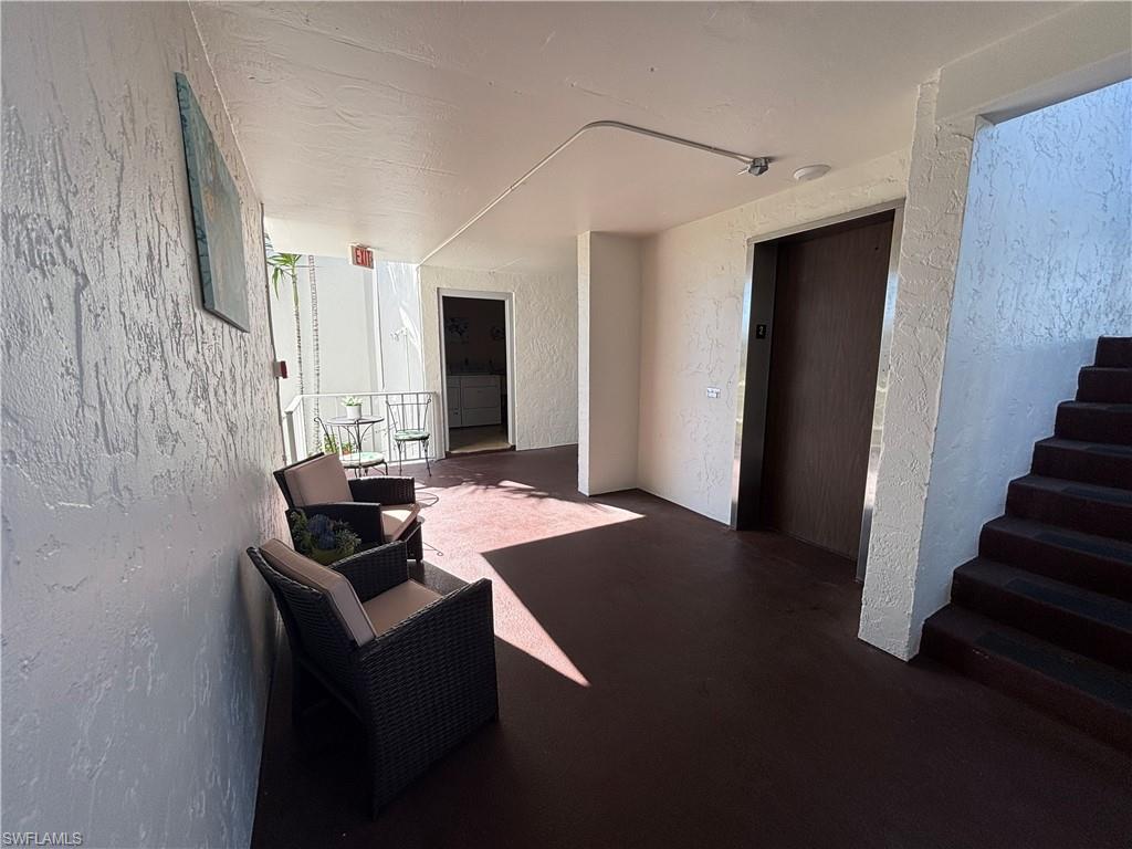 Elevators with seating area and entrance to Laundry room