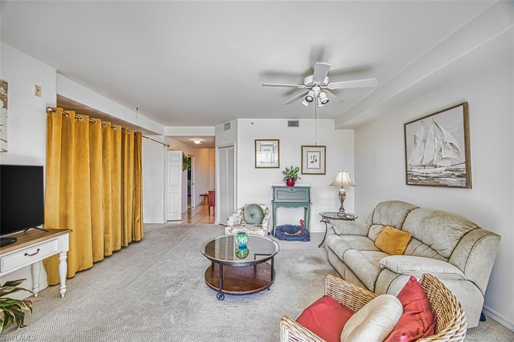 Carpeted living room with ceiling fan