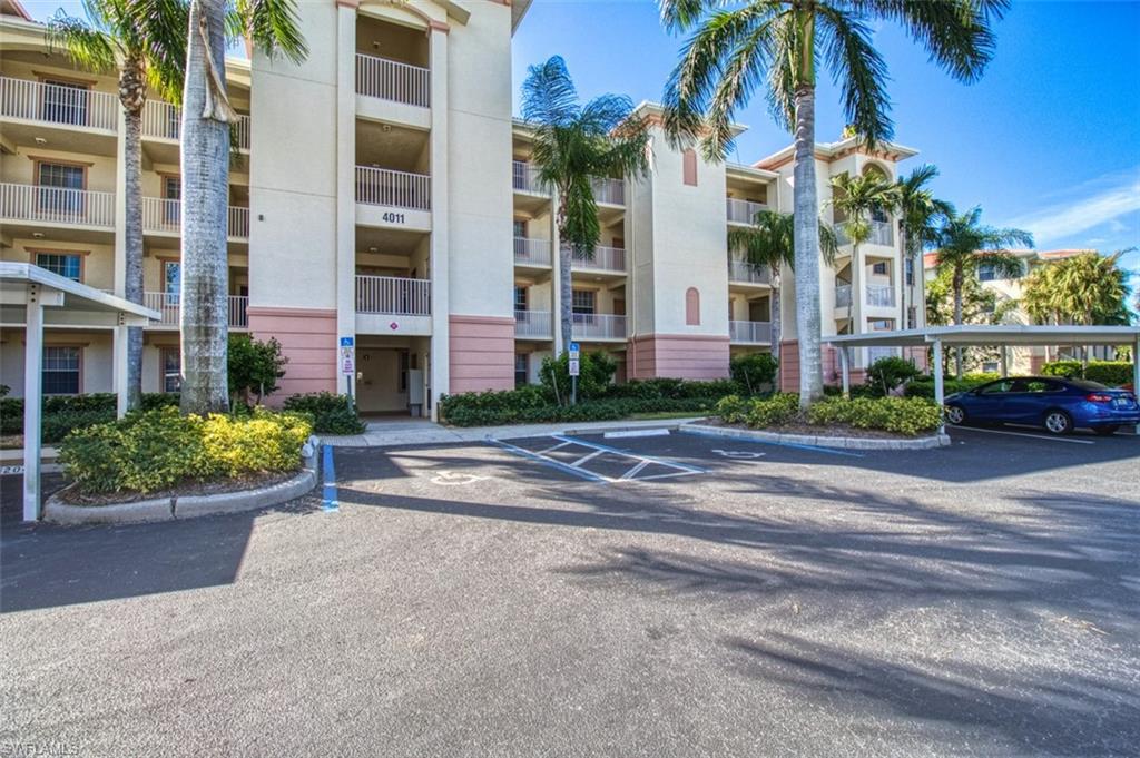 View of apartment building / complex featuring uncovered parking