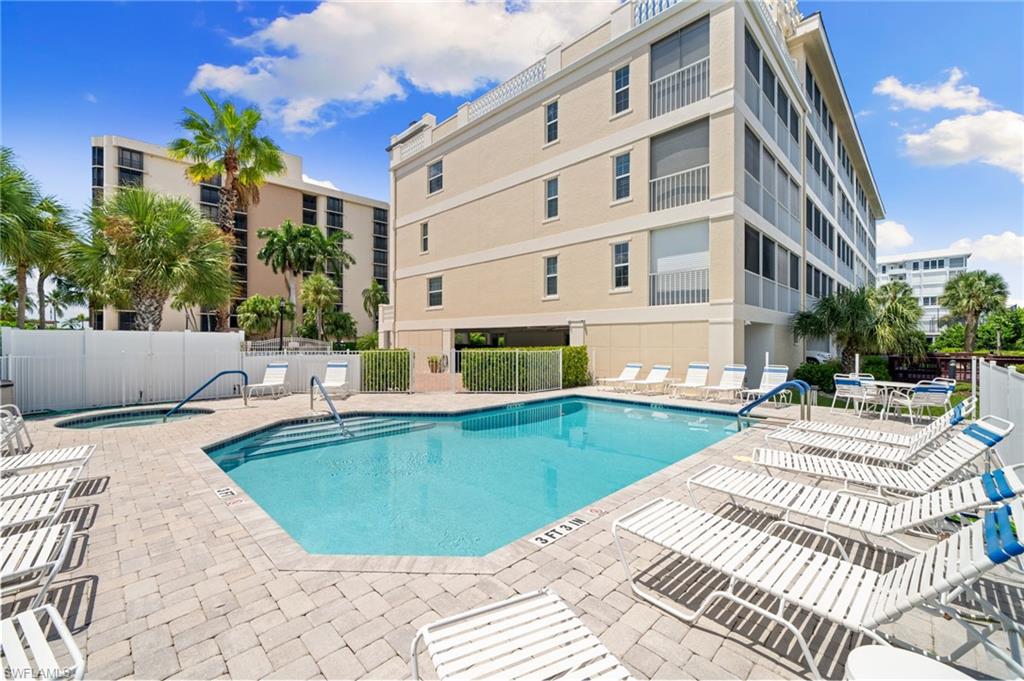 Community pool with a patio area and a hot tub