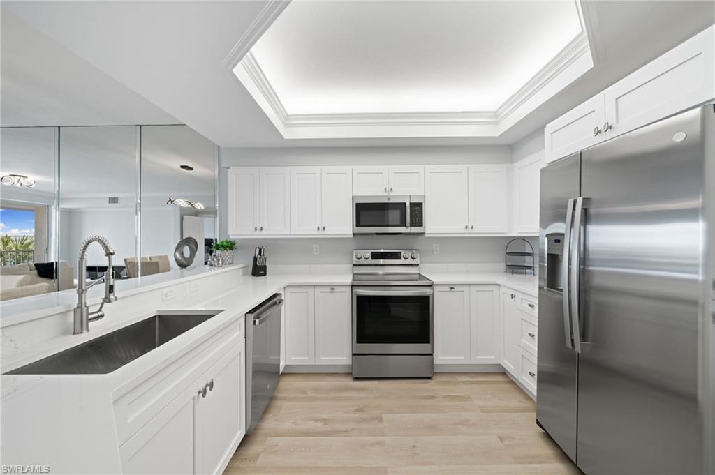Kitchen featuring appliances with stainless steel finishes, white cabinetry, and light wood-type flooring