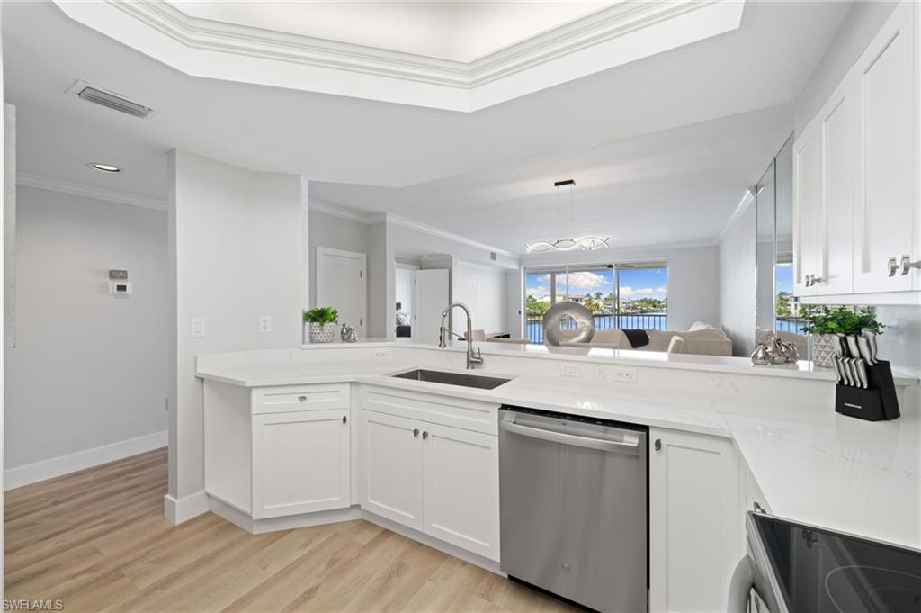 Kitchen featuring stainless steel dishwasher, crown molding, white cabinetry, electric range, and light stone countertops