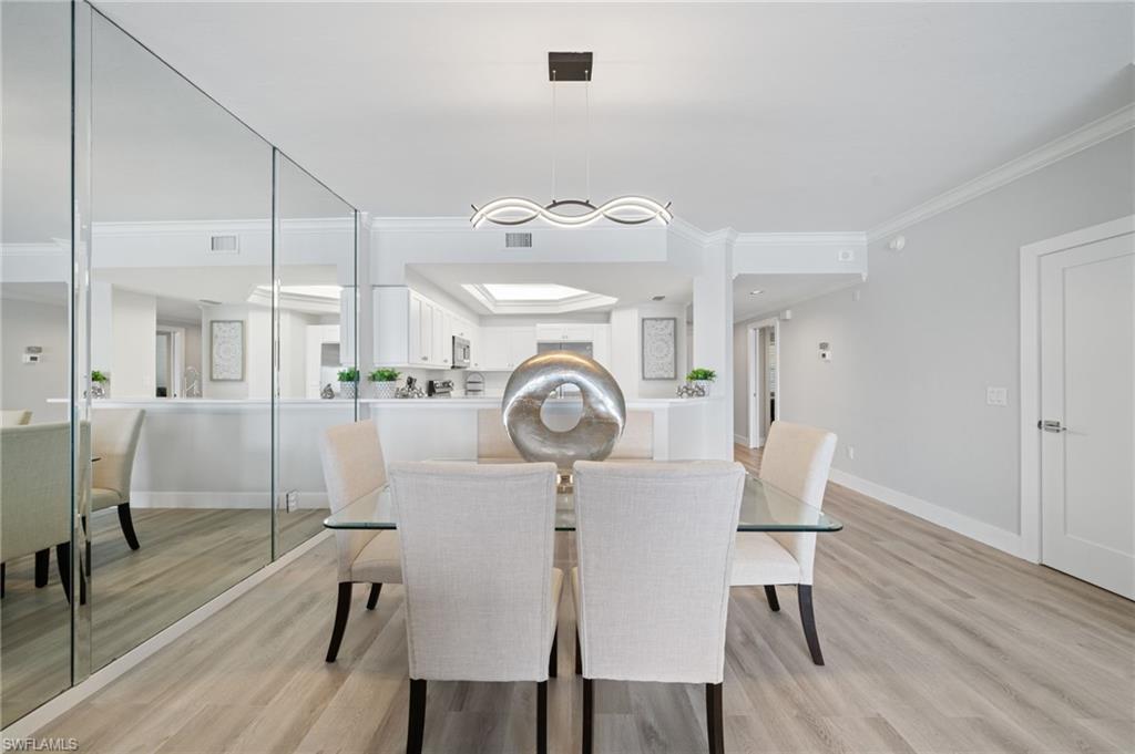 Dining space featuring light wood finished floors and crown molding