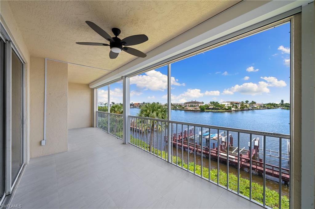 Unfurnished sunroom with a water view, a textured ceiling, and floor to ceiling windows