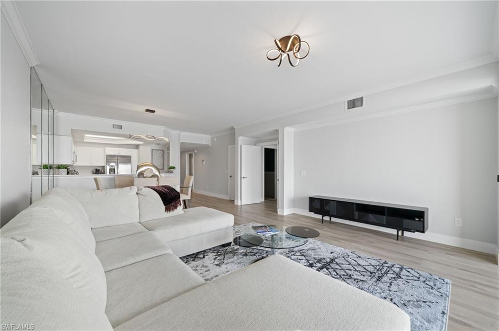 Living room featuring crown molding and light wood-type flooring