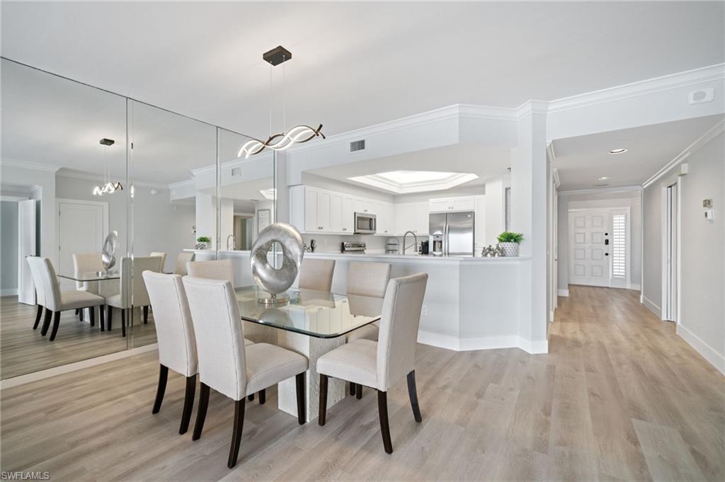Dining area featuring ornamental molding and light wood-type flooring
