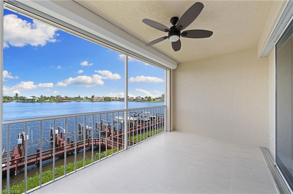 Balcony featuring a ceiling fan and a water view