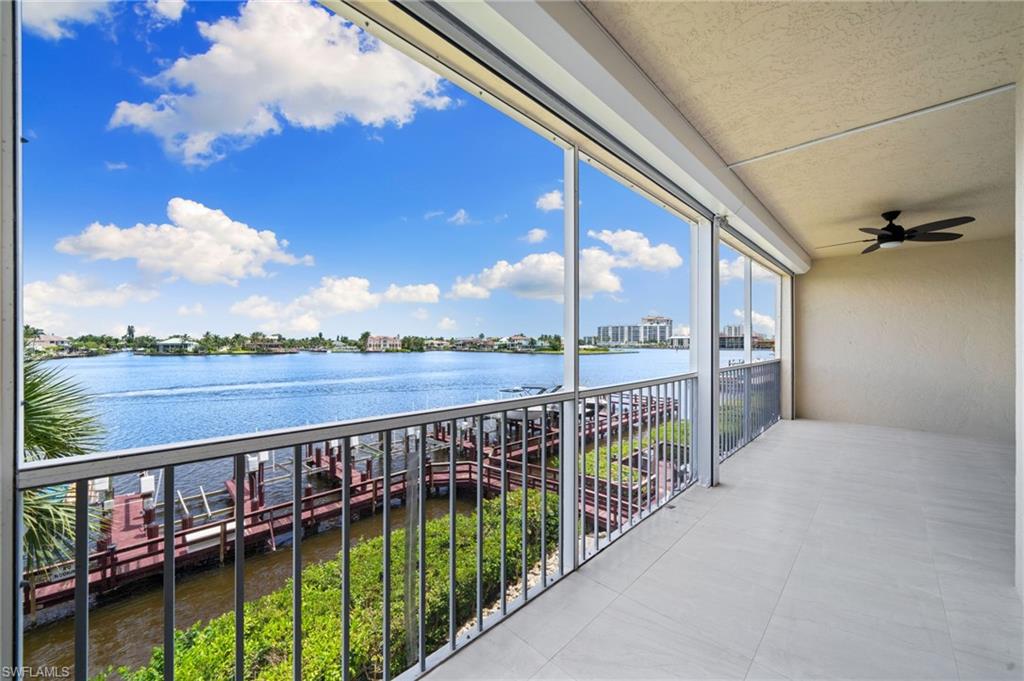 Balcony with a sunroom, a water view, and ceiling fan