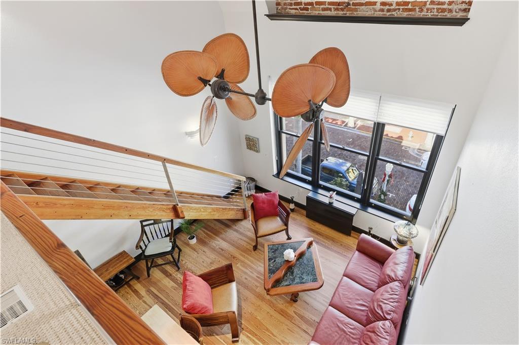 Upstairs Living area view from the loft/ den featuring hardwood / wood floors and a high ceiling