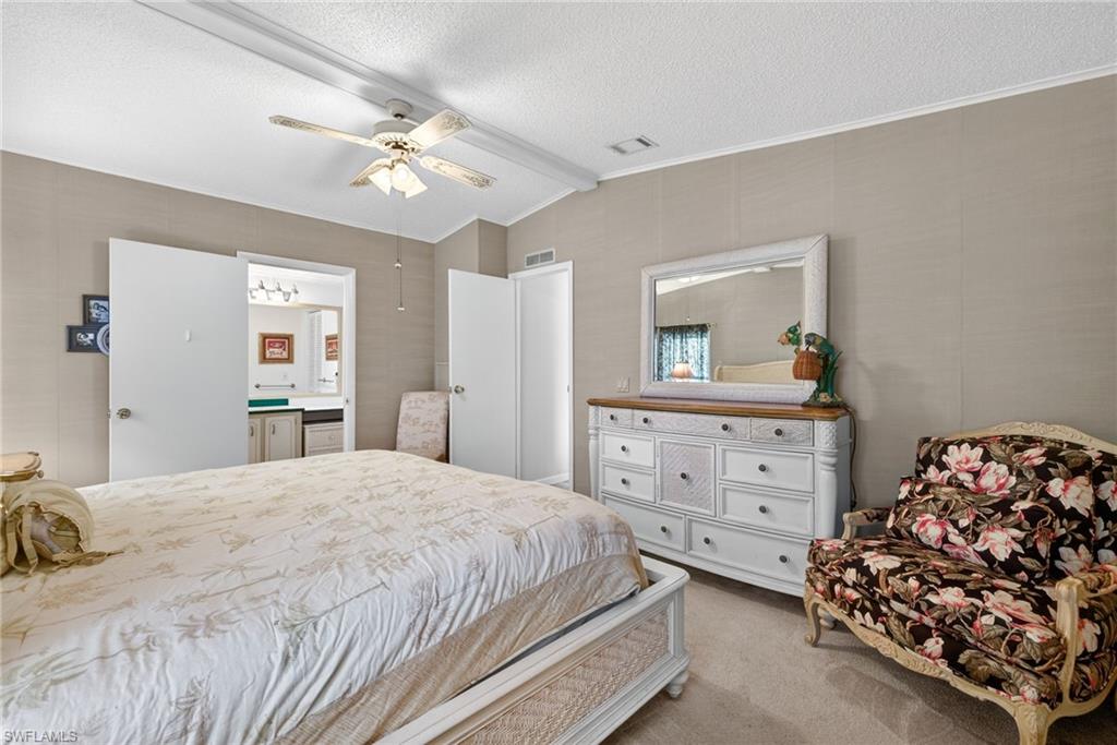 Bedroom featuring carpet flooring, a textured ceiling, and ceiling fan