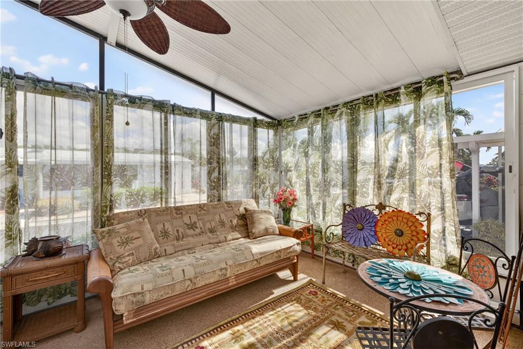 Sunroom featuring a ceiling fan, an outdoor hangout area, and lofted ceiling