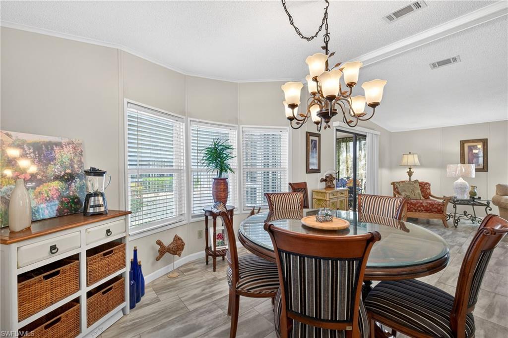 Dining area featuring ornamental molding, a chandelier, and a textured ceiling