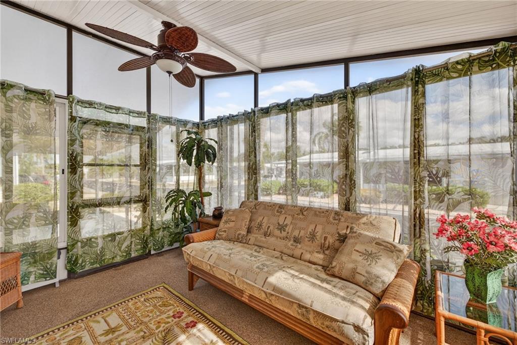 Sunroom featuring expansive windows and carpet