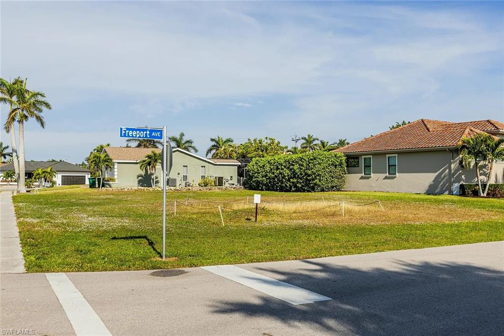 View of green lawn with a residential view