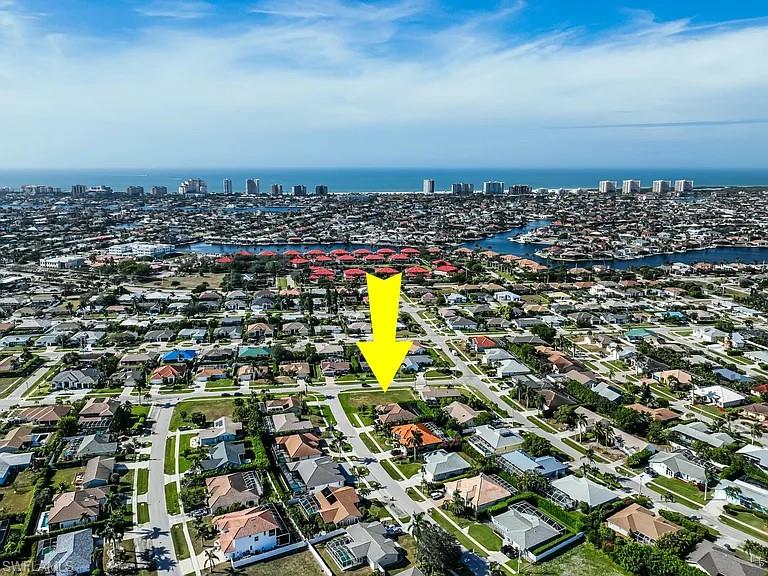 Aerial view of property and surrounding area with a nearby body of water and nearby urban area