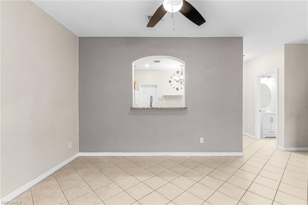 Empty room with light tile patterned floors and a ceiling fan