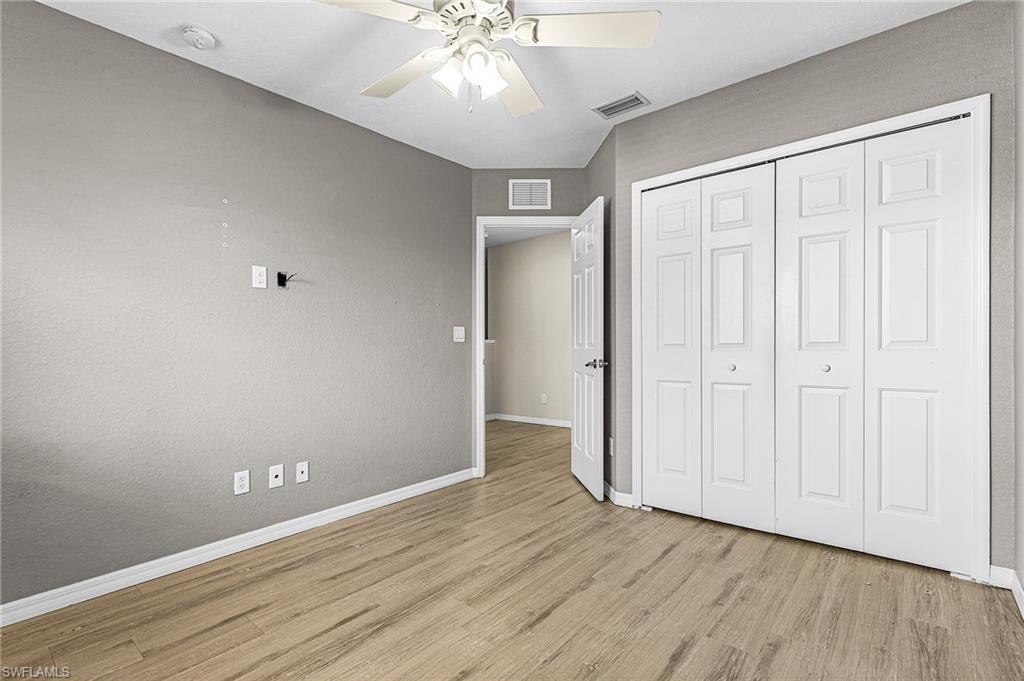 Unfurnished bedroom featuring light wood finished floors, a closet, and a ceiling fan