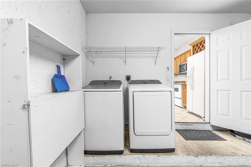 Washroom featuring washer and clothes dryer and light tile patterned flooring