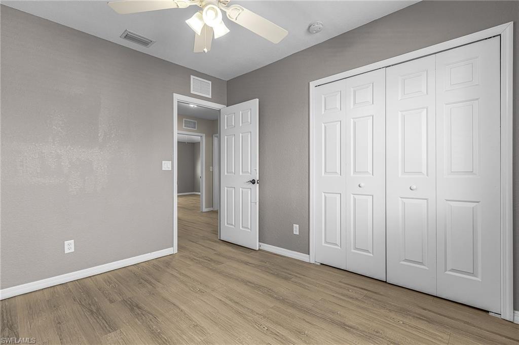 Unfurnished bedroom with light wood-style floors, a ceiling fan, and a closet