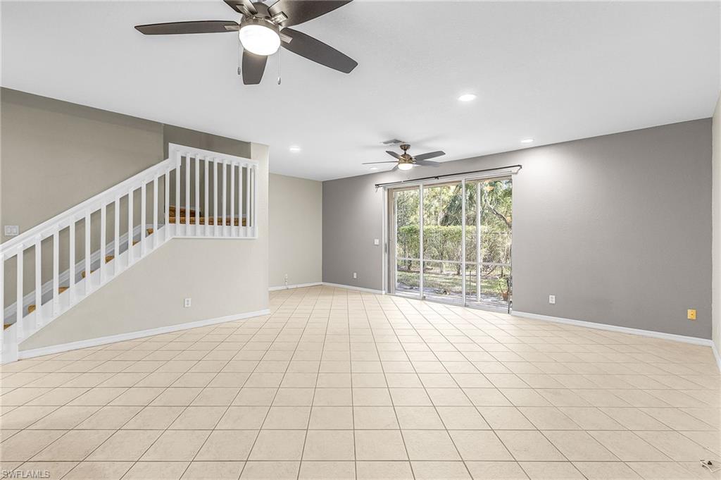 Unfurnished living room featuring recessed lighting, ceiling fan, and stairway