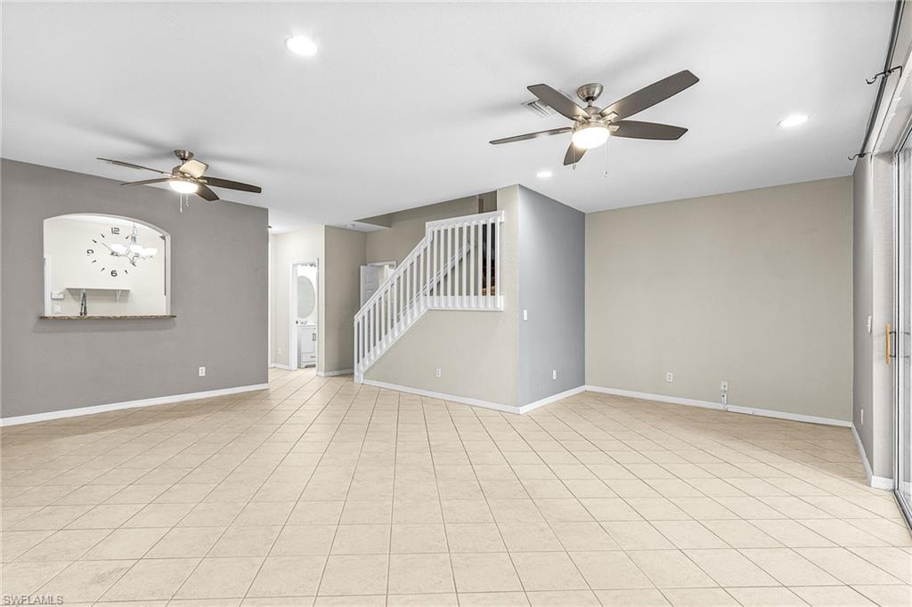 Unfurnished room with ceiling fan, stairway, recessed lighting, and light tile patterned flooring