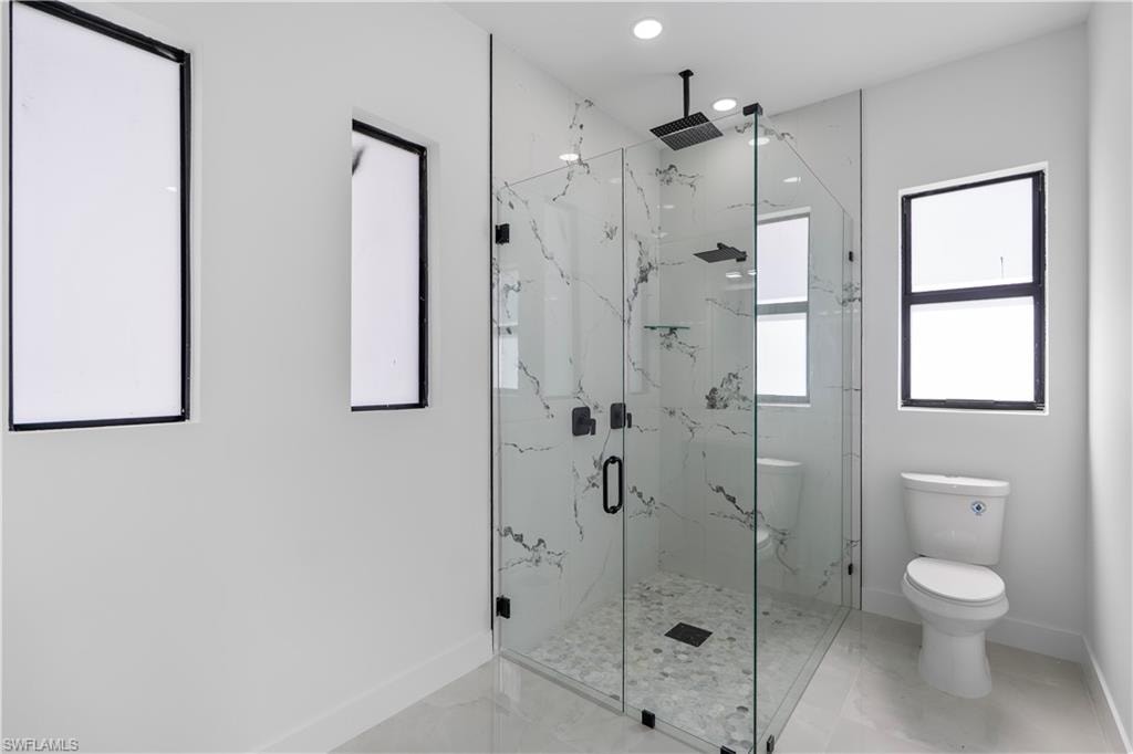 Full bathroom with a marble finish shower and recessed lighting