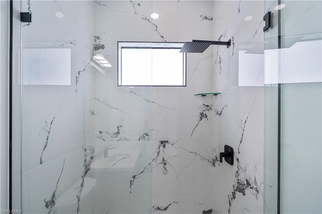 Bathroom featuring a marble finish shower