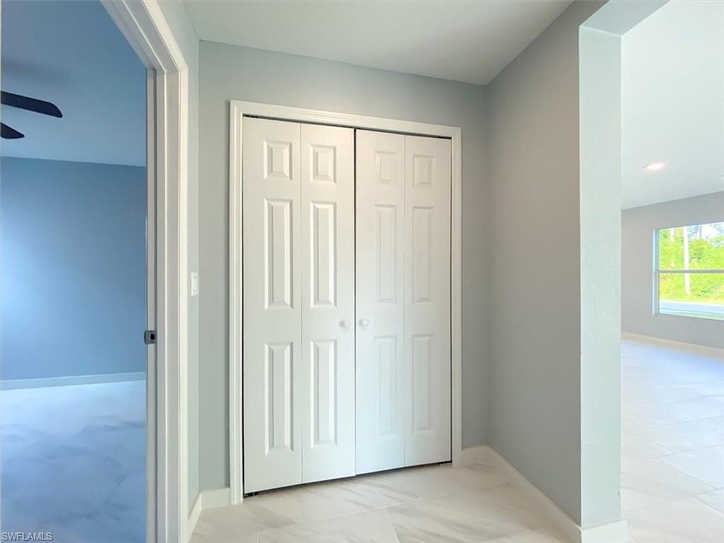 Hall with light marble finish floors and baseboards
