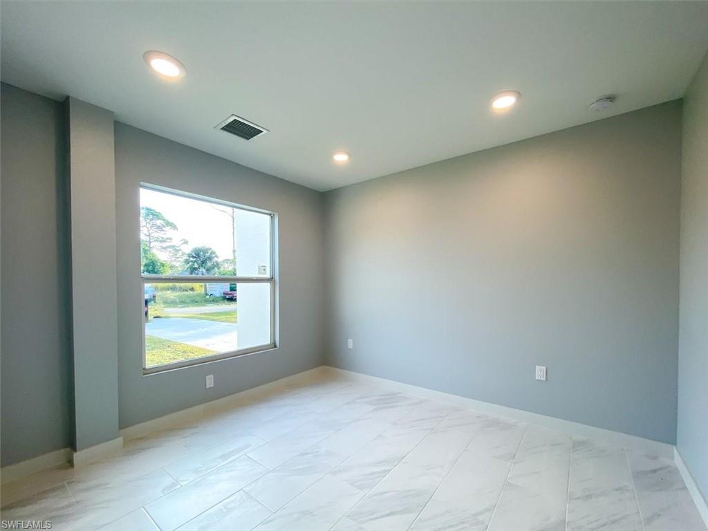 Spare room featuring light marble finish flooring and recessed lighting