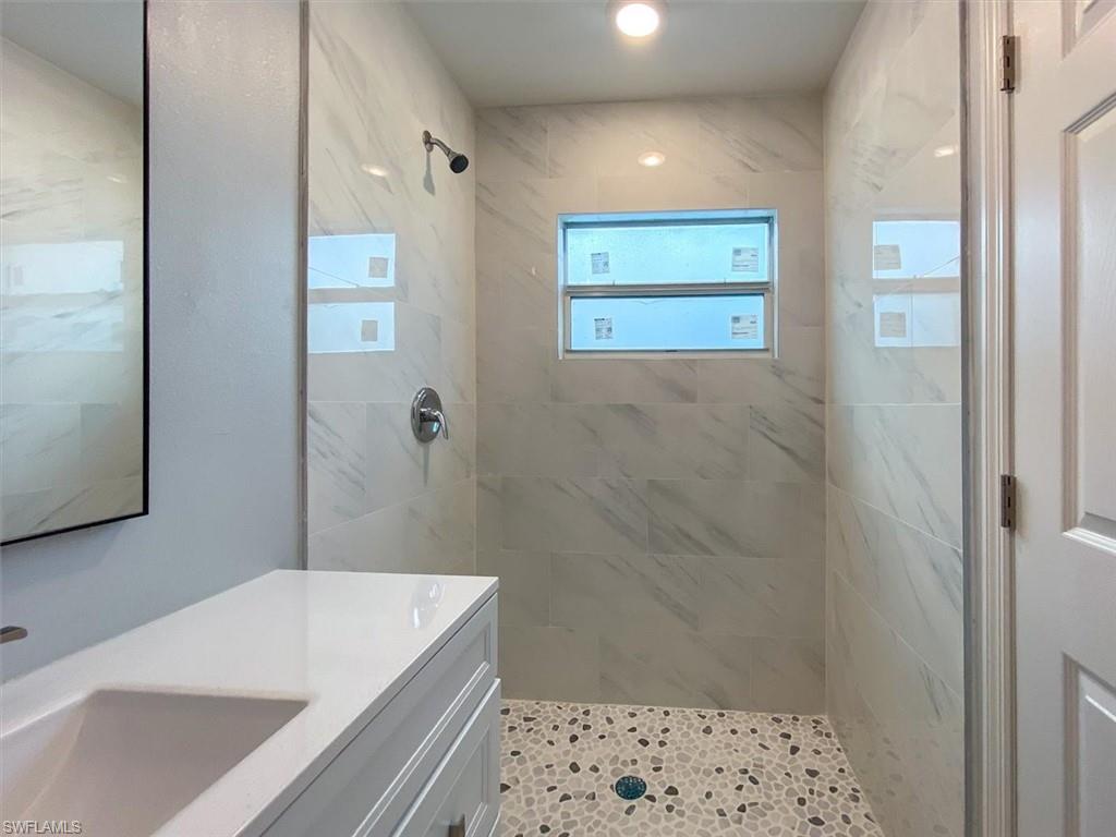 Full bathroom with a marble finish shower and vanity