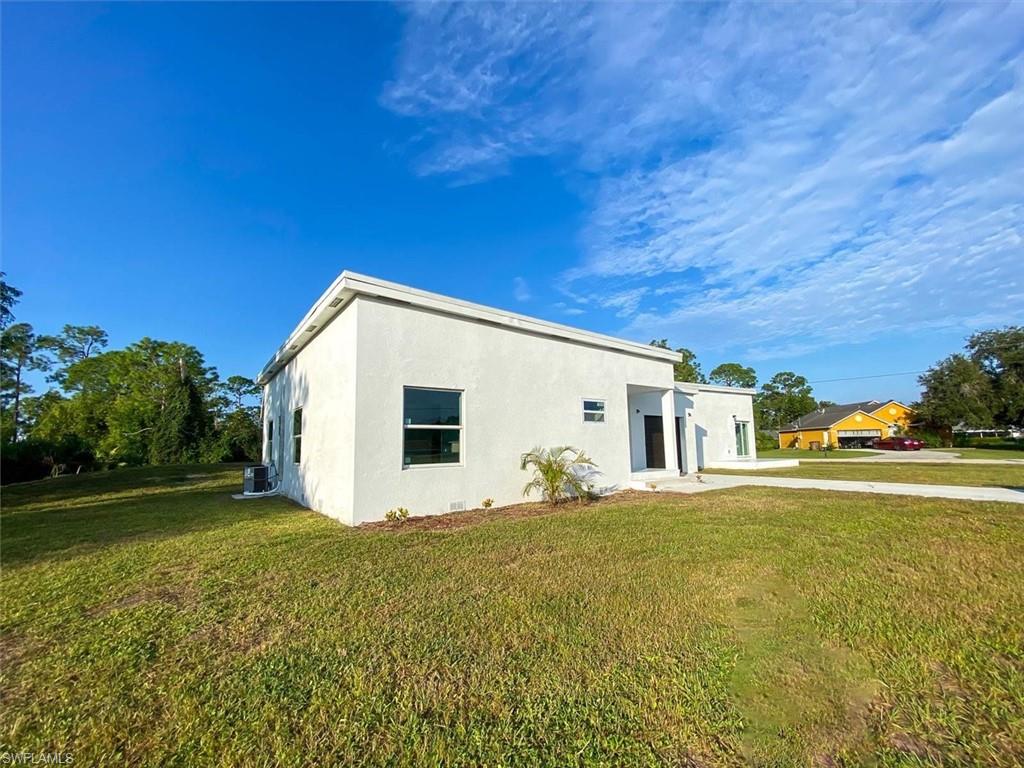 View of front facade featuring a front lawn and stucco siding