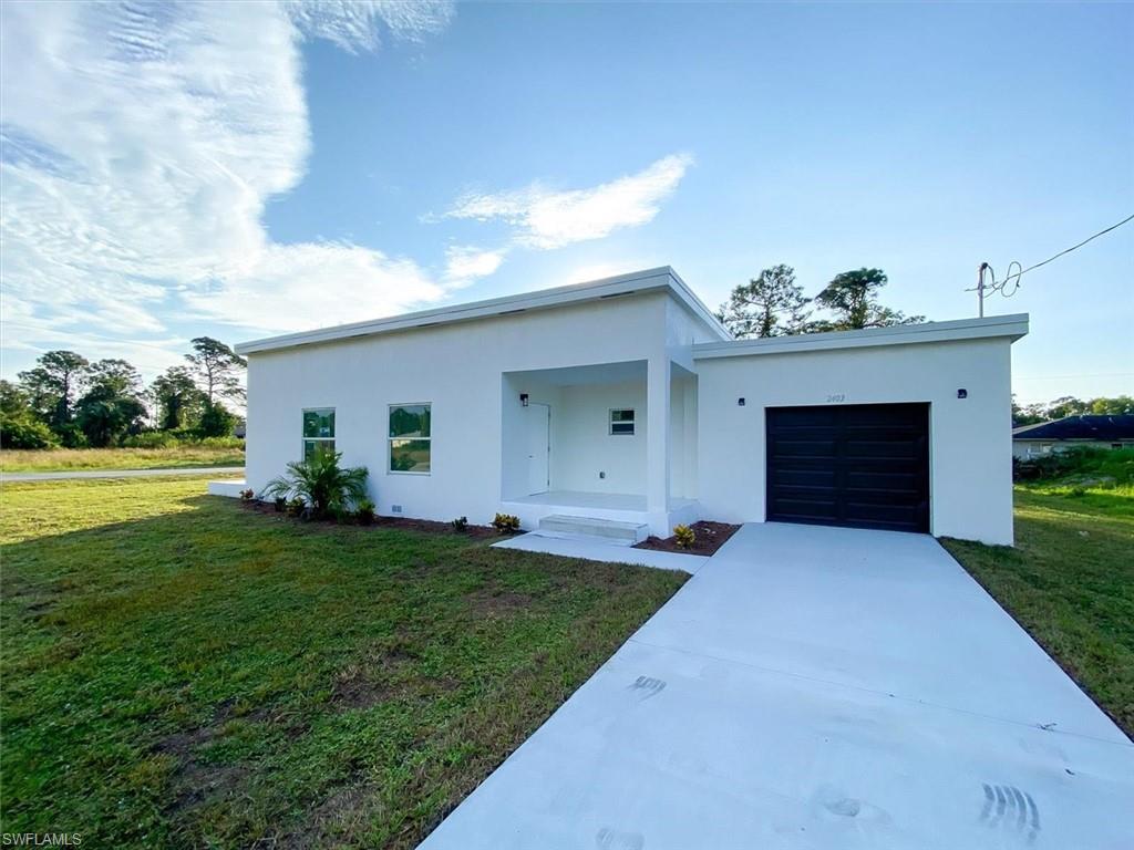 Contemporary home with stucco siding, a garage, a front lawn, and concrete driveway