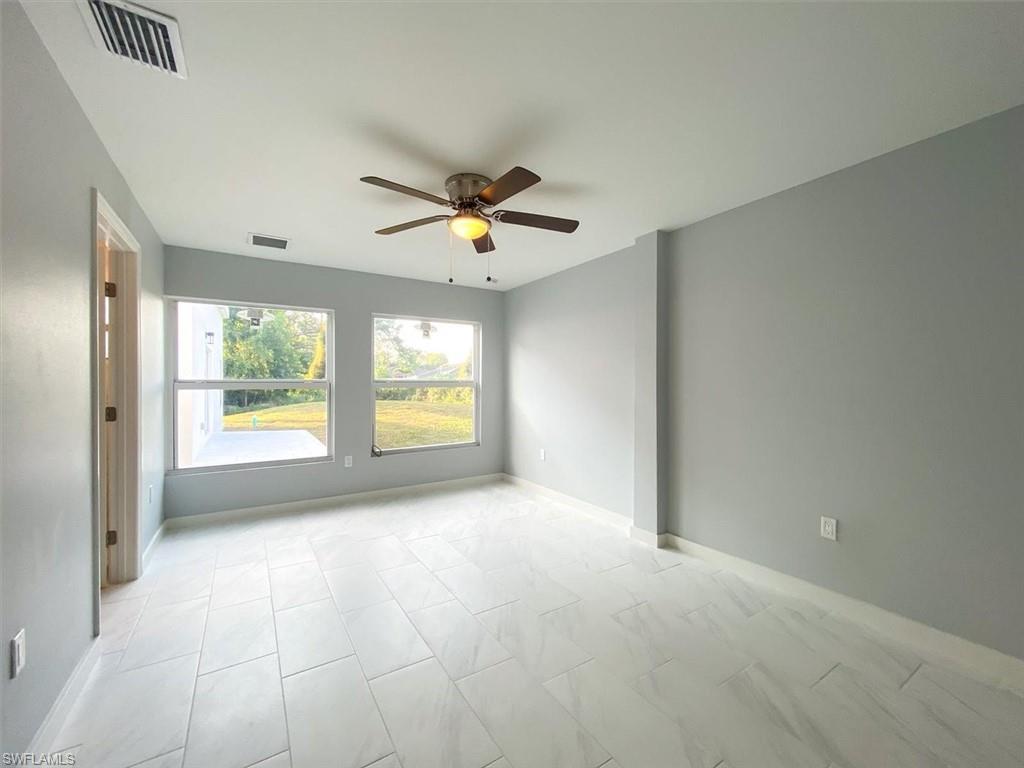 Unfurnished room with ceiling fan and baseboards
