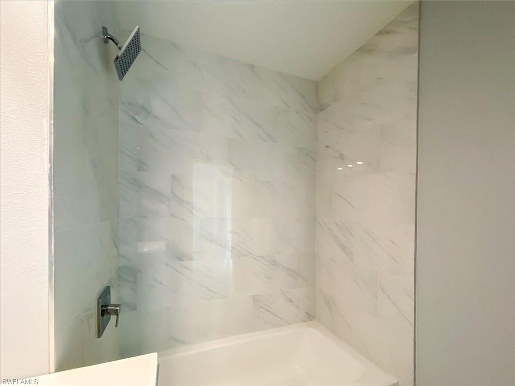 Full bathroom with a combined bath / shower with marble appearance