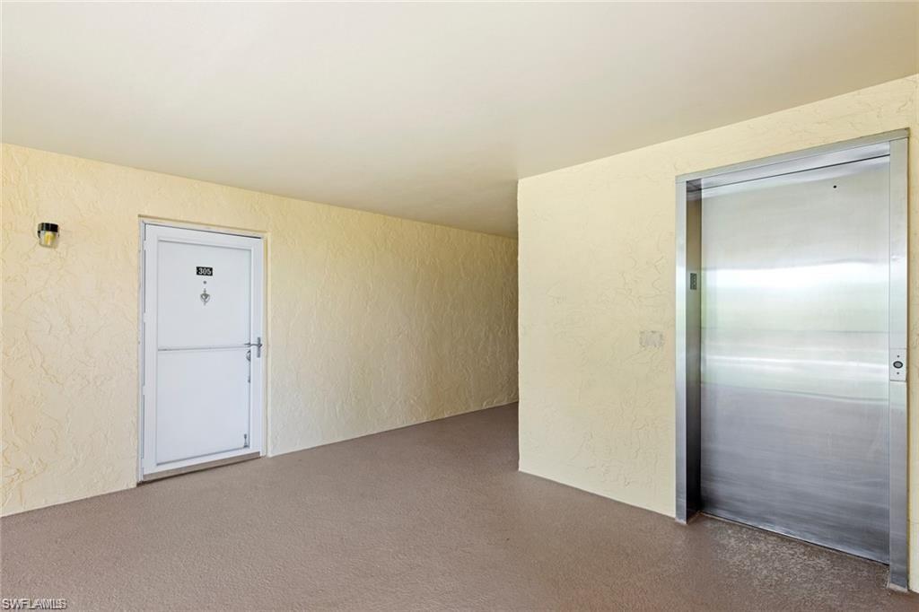 Empty room with a textured wall and elevator