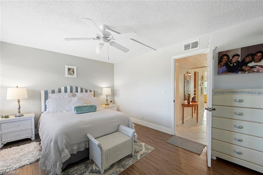 Bedroom with wood finished floors, a ceiling fan, and a textured ceiling