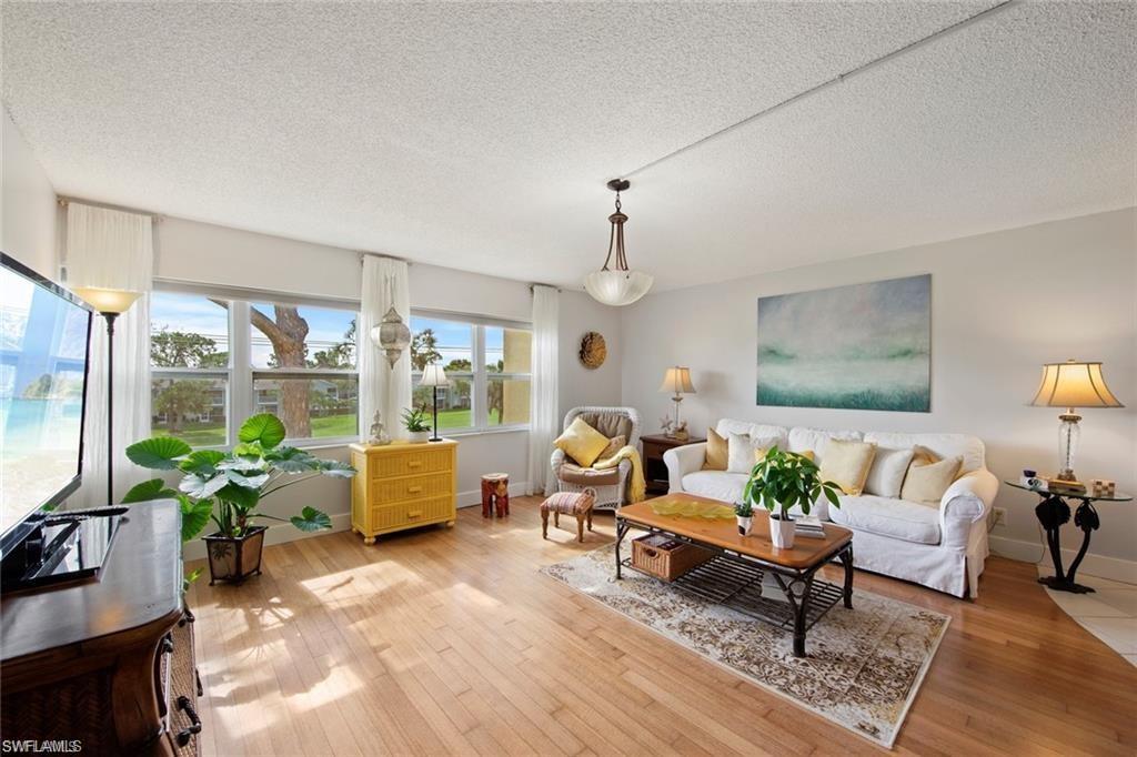 Living room with a textured ceiling and light wood finished floors