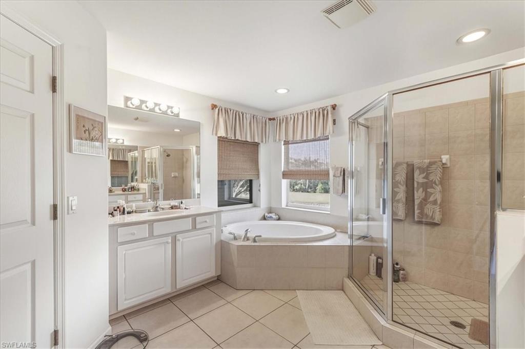 Full bathroom with a bath, a stall shower, vanity, and light tile patterned flooring