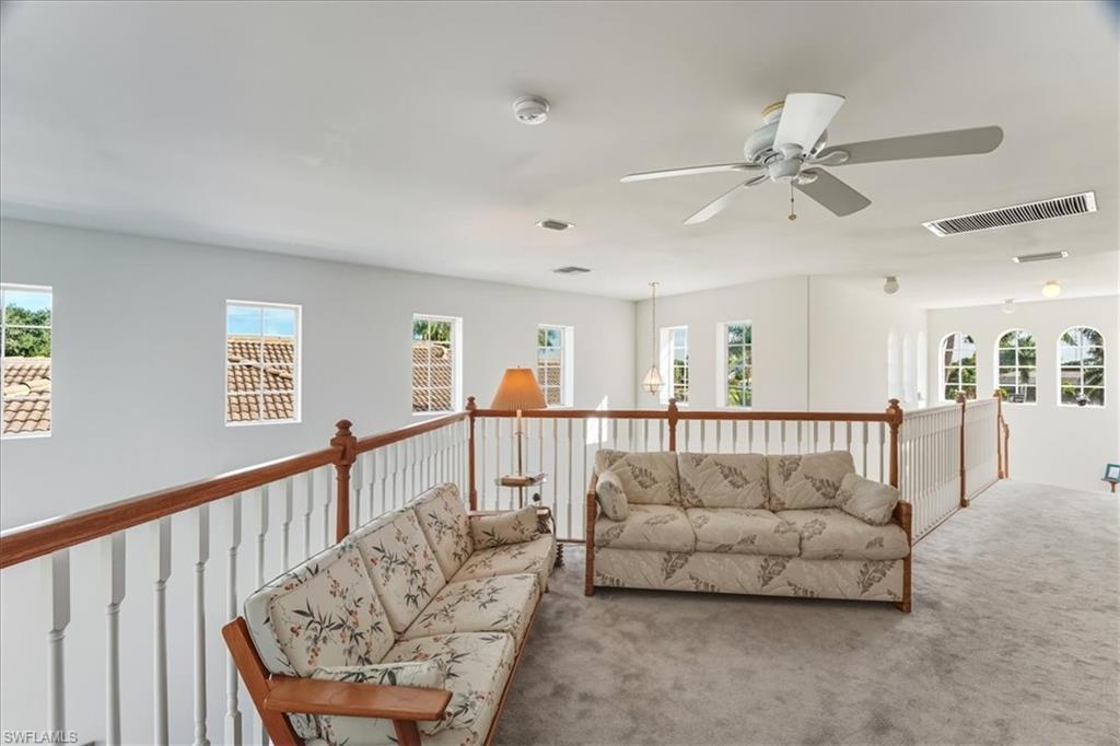 Carpeted living room with a ceiling fan