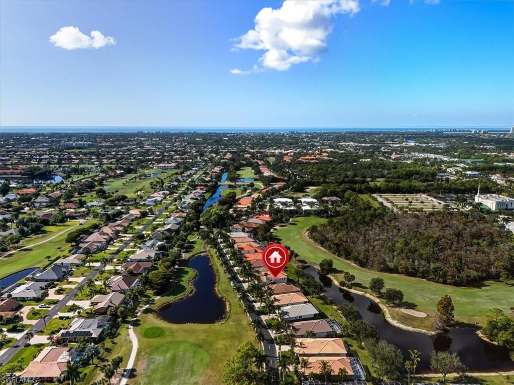 Aerial overview of property's location featuring a golf course and nearby suburban area