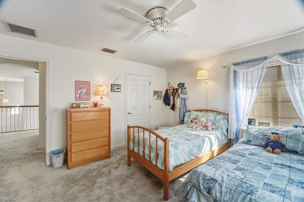 Carpeted bedroom featuring ceiling fan