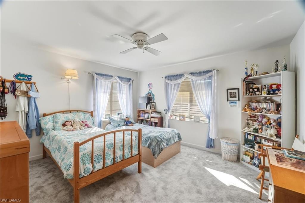 Bedroom with carpet flooring, a ceiling fan, and an office area