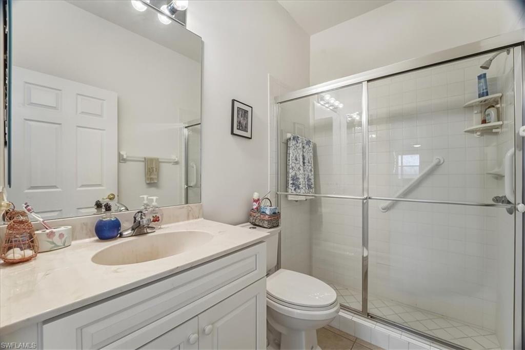 Full bathroom with vanity, a shower stall, and light tile patterned floors