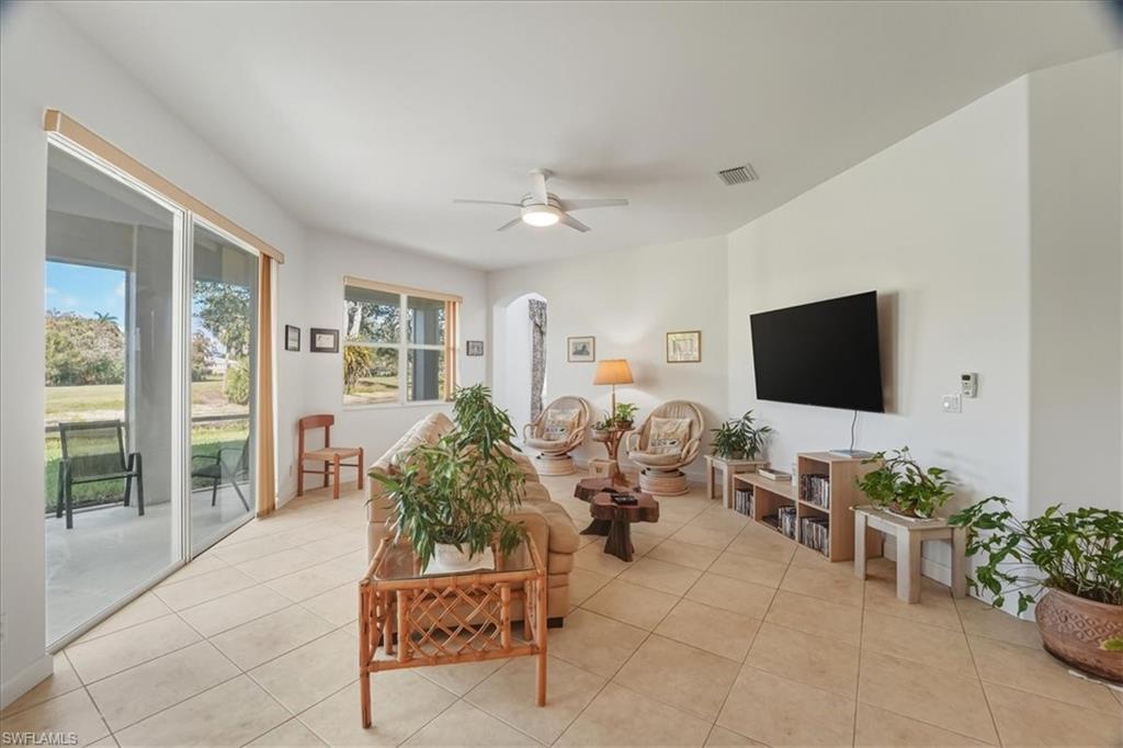 Living area with light tile patterned flooring and ceiling fan
