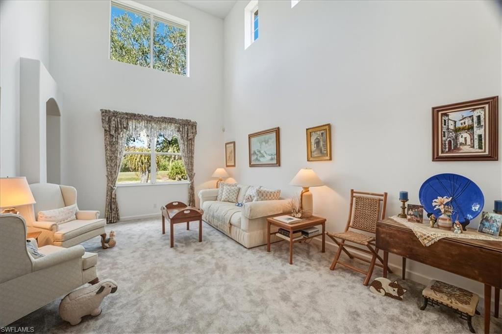 Living room featuring carpet and a towering ceiling
