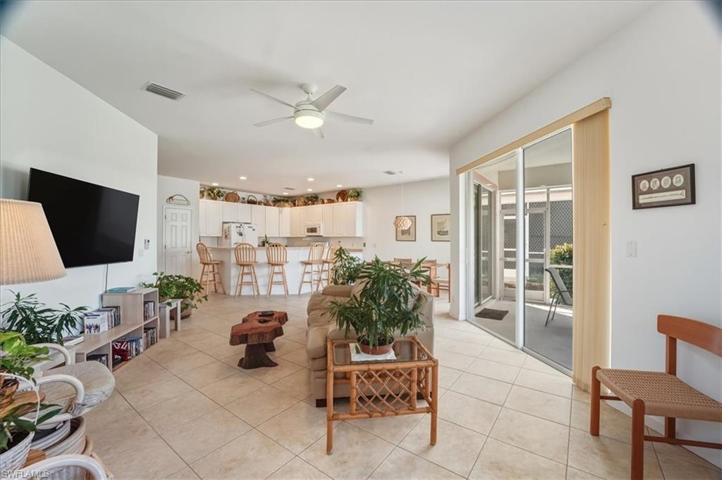 Living room with ceiling fan and light tile patterned floors